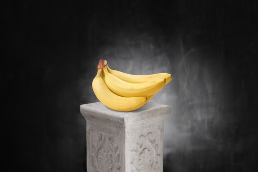 Bunch of yellow bananas on a pedestal.