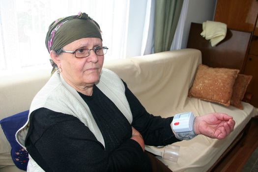 old lady measuring blood pressure at home