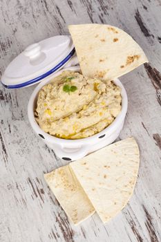 Hummus with pita bread on white wooden background. Culinary mediterranean eating. 