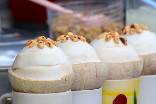 Coconut ice cream in coconut shell and topped with roasted peanuts.