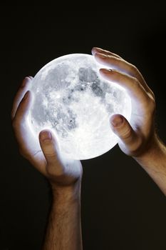 Man holding the Moon in his hands. Moon image provided by NASA.