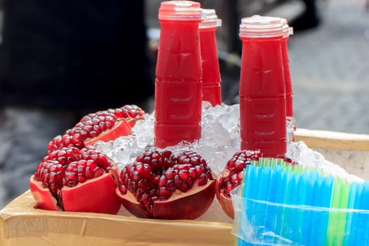 Pomegranate with pomegranate juice in a bottle on ice.