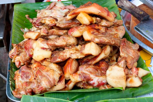 Roasted pork is placed on a banana leaf.