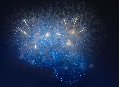 Fireworks in night dark sky with smoke after explosions