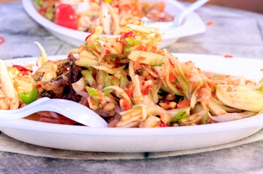 A spicy mango salad with fried fish.