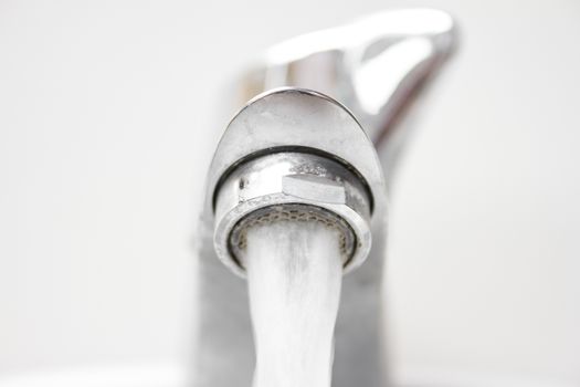 Front view of modern style opened dirty faucet closeup view with small depth of field