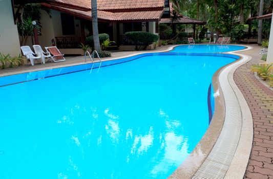 Outdoor in ground residential swimming pool in backyard.
