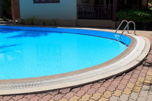 Outdoor in ground residential swimming pool in backyard.