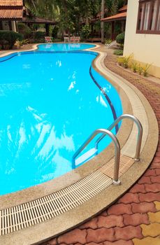 Swimming pool with stair at hotel close up 