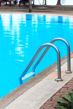 Swimming pool with stair at hotel close up 
