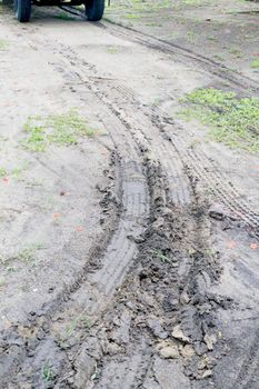An image of a tire track on the soil.