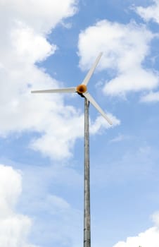 Wind turbine under a blue sky from Lumpini park in bangkok.