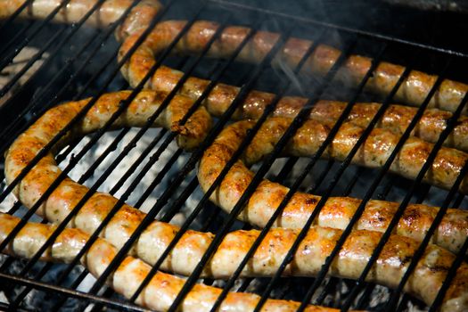 Grilled sausage while cooking on the barbecue