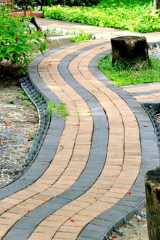 Walkwalk made of bricks in various colors at garden.
