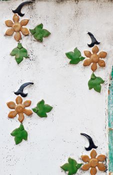 Wall paintings is painted green leaves and flower with white background.