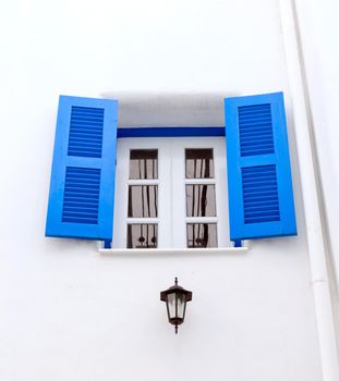 Blue window with white wall of shopping center.