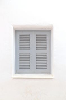 Gray window with white wall of shopping center.