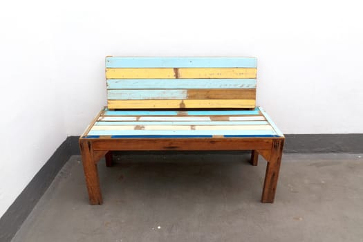 A old wooden chair with white walls.