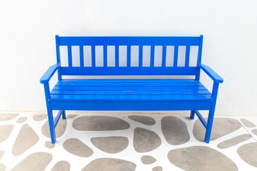 A blue wooden chair with white walls.
