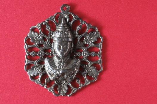 Silver Buddha Pendant Jewel over a Colored Background