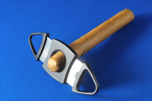 Cuban Brown Havan Cigar and Cutter on a Colored Background