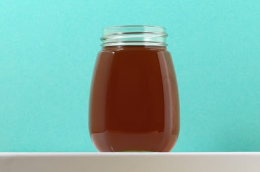 One Full Honey Jar on a Colored Background