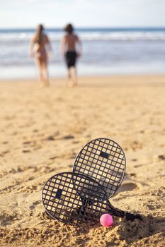 Boy and girl go for a swim at the beach after playing tennis