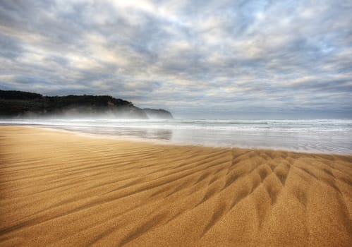 Beautiful beach of North Spain with waves  marks in the sand