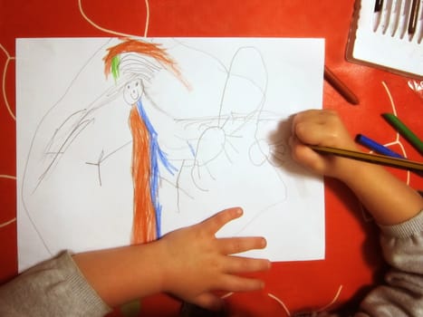 Girl drawing a picture with colored pencils.