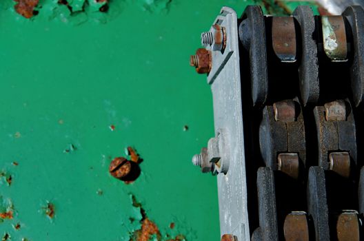 Iron components on green rusty background whit screws.