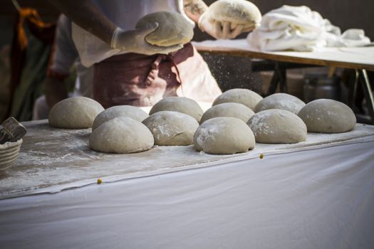 Baker making artisan bread in a medieval fair