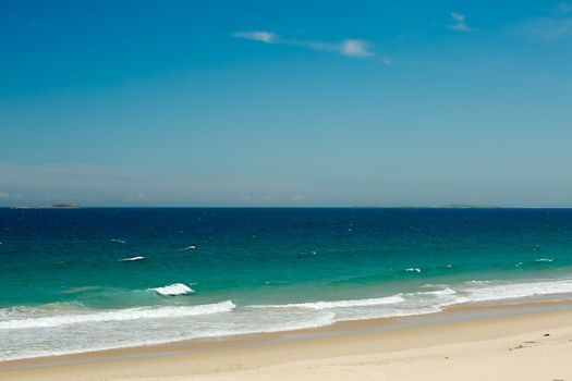 Sandy beach with waves of the see