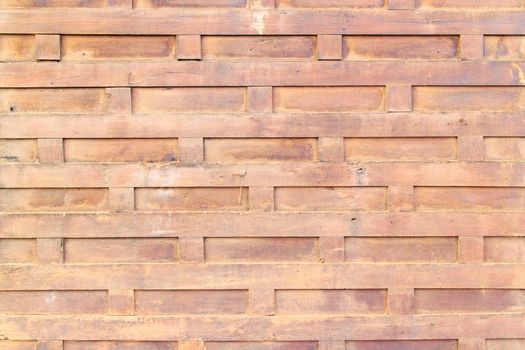 The ancient brown wooden wall arranged in a square pattern.