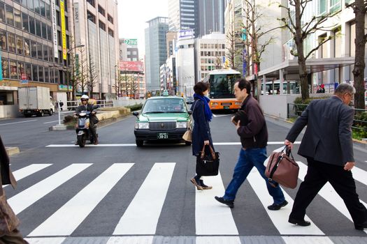 Tokyo, Japan - April 12, 2014 Tourists and business people crossing the street at Shinjuku