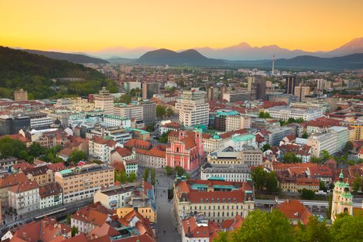 Panorama of the Slovenian capital Ljubljana at sunset. Alps mountains