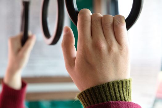 people holding onto a handle on a bus