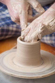 Hands of a potter, creating an earthen jar on the circle