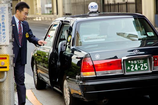 Tokyo Japan - April 12 2014 Japanese businessmen call a taxi to work in the morning Traditional Japanese taxi on the streets of Tokyo
