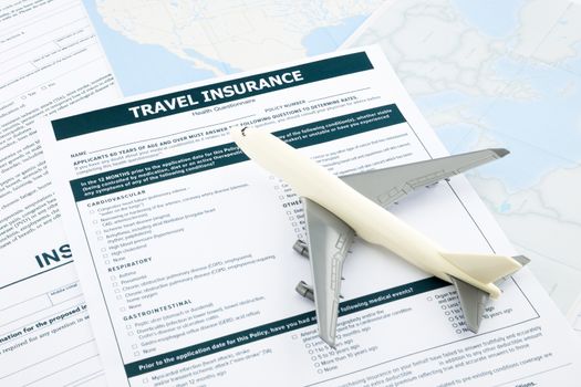 travel insurance form and   plane model on world map paperwork, concept and idea for insurance business