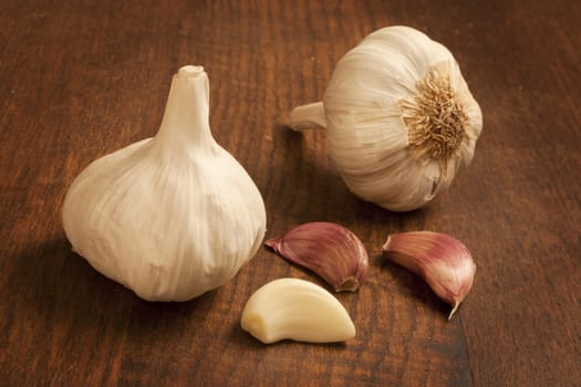 Whole and peeled garlic on a kitchen table.