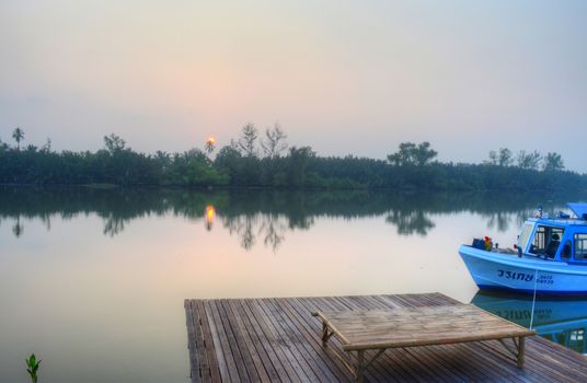 Lanscape of Misty Morning Countryside with Sunrise, River, Boat, Coconut Tree and Garden.Chachoensao province,Thailand.