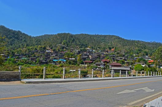 On Asphalt Road pass Country Village 1_2, Bridge, Blue Sky, Direction, Traffic Sign, Maehongson province, Thailand