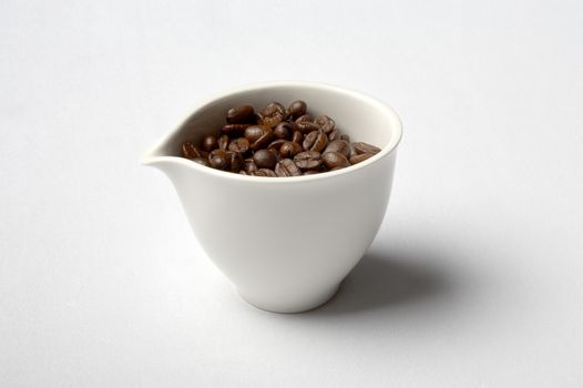 white porcelain cup full of colombian coffee beans