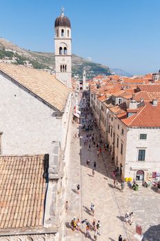 DUBROVNIK, CROATIA - AUGUST 18: Tourists walks on the Placa (Stradun), main street of Dubrovnik on August 18, 2013 in Dubrovnik. The street runs 300 metres through the Old Town, the historic part of the city surrounded by the Walls of Dubrovnik.