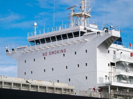 Cargo ship anchored in port, side view of ship's superstructure