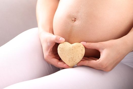 Pregnant woman showing heart symbol