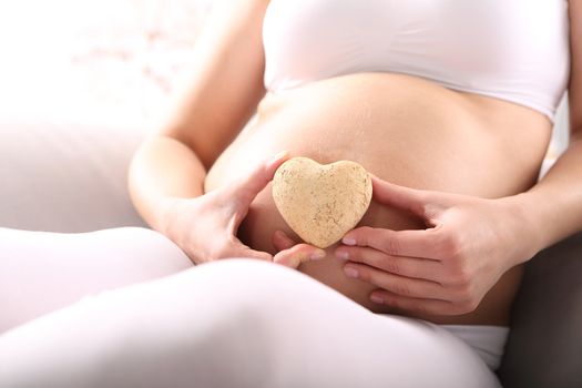 Pregnant woman showing heart symbol