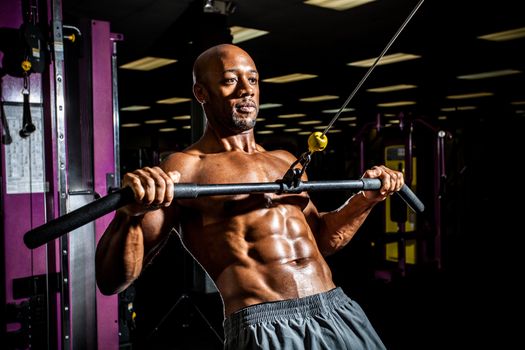 Ripped body builder working out  at the gym.