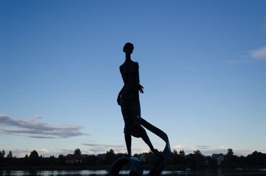 magnificent black texture thin woman with wavy ribbon sculpture surrounded by night dark