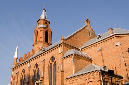 gothic church with crosses and arched windows on blue sky background